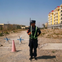 A Chinese police officer stands near what is officially described as a vocational education center in Yining in Xinjiang Uighur Autonomous Region, China, in September 2018. | REUTERS