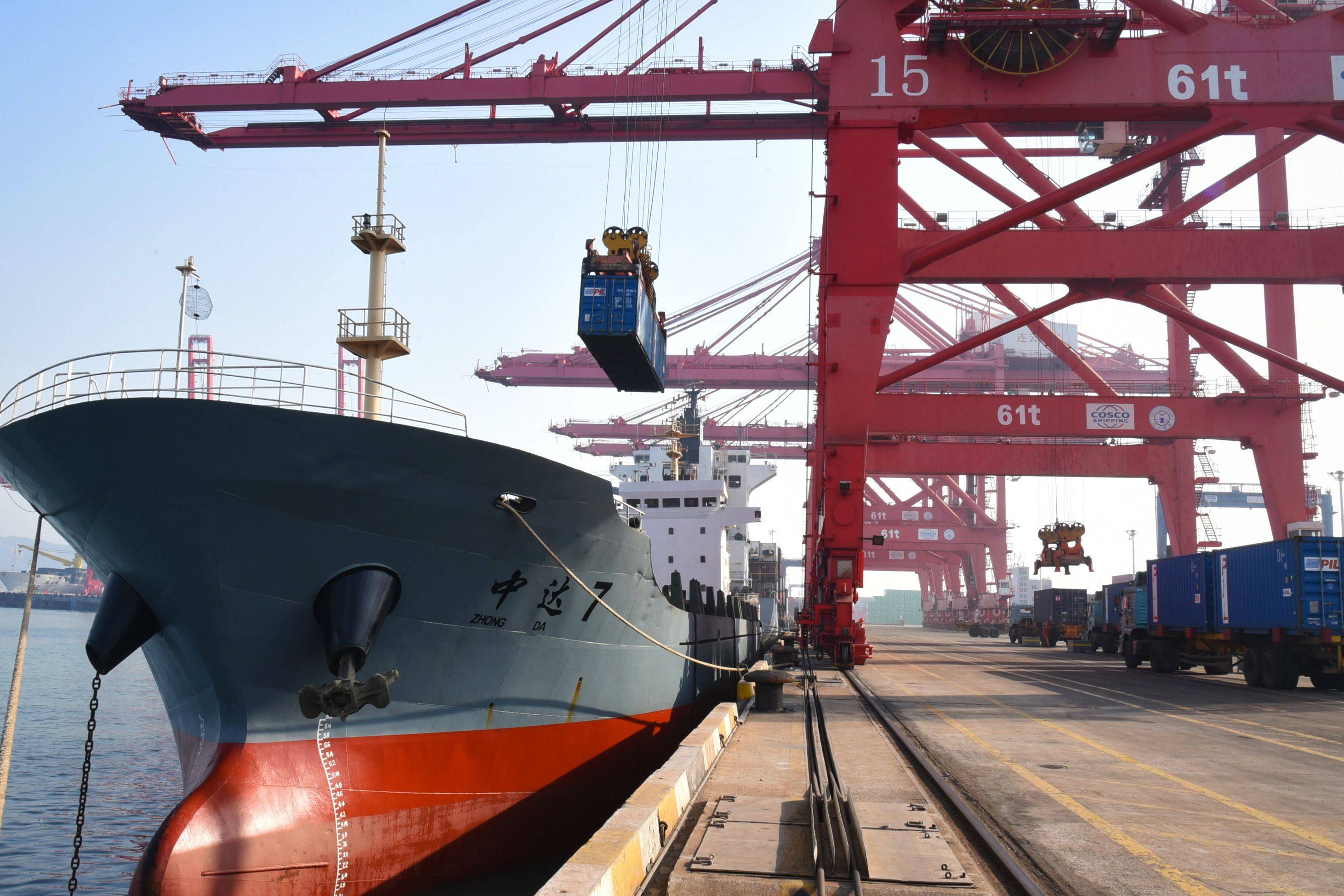 A container is loaded onto a cargo ship at a port in Lianyungang in China's eastern Jiangsu province on Thursday. Already the world’s top exporter, China’s shipments increased 3.6% in 2020, according to official data. | STR / via AFP-JIJI