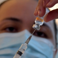 A Brazilian health worker prepares a dose of a coronavirus vaccine in Sao Paulo on Sunday. | AFP-JIJI
