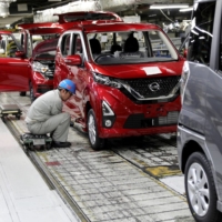 A Nissan Motor Co. employee works on the assembly line at a plant in Kurashiki, Okayama Prefecture. Nissan is moving to promote all contract workers in Japan to full-time positions. | BLOOMBERG