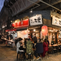 People dine at a restaurant at the Ameya Yokocho market in the Ueno district of Tokyo on Dec. 30. | BLOOMBERG