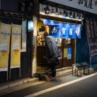 A customer walks into a restaurant in Tokyo on Jan. 8. | BLOOMBERG