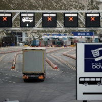 A truck drives toward the entrance to the Port of Dover in England. U.K. exporters say they are struggling to acquire transit documents, which allow goods to enter the European Union without delay, because of a shortage of agents with the authority to issue them. | REUTERS