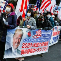 Supporters of U.S. President Donald Trump hold a rally in Tokyo on Wednesday ahead of the inauguration of President-elect Joe Biden in Washington. | REUTERS