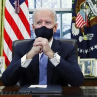 U.S. President Joe Biden signs executive orders in the Oval Office of the White House in Washington, after his inauguration as the 46th president of the United States on Wednesday. | REUTERS