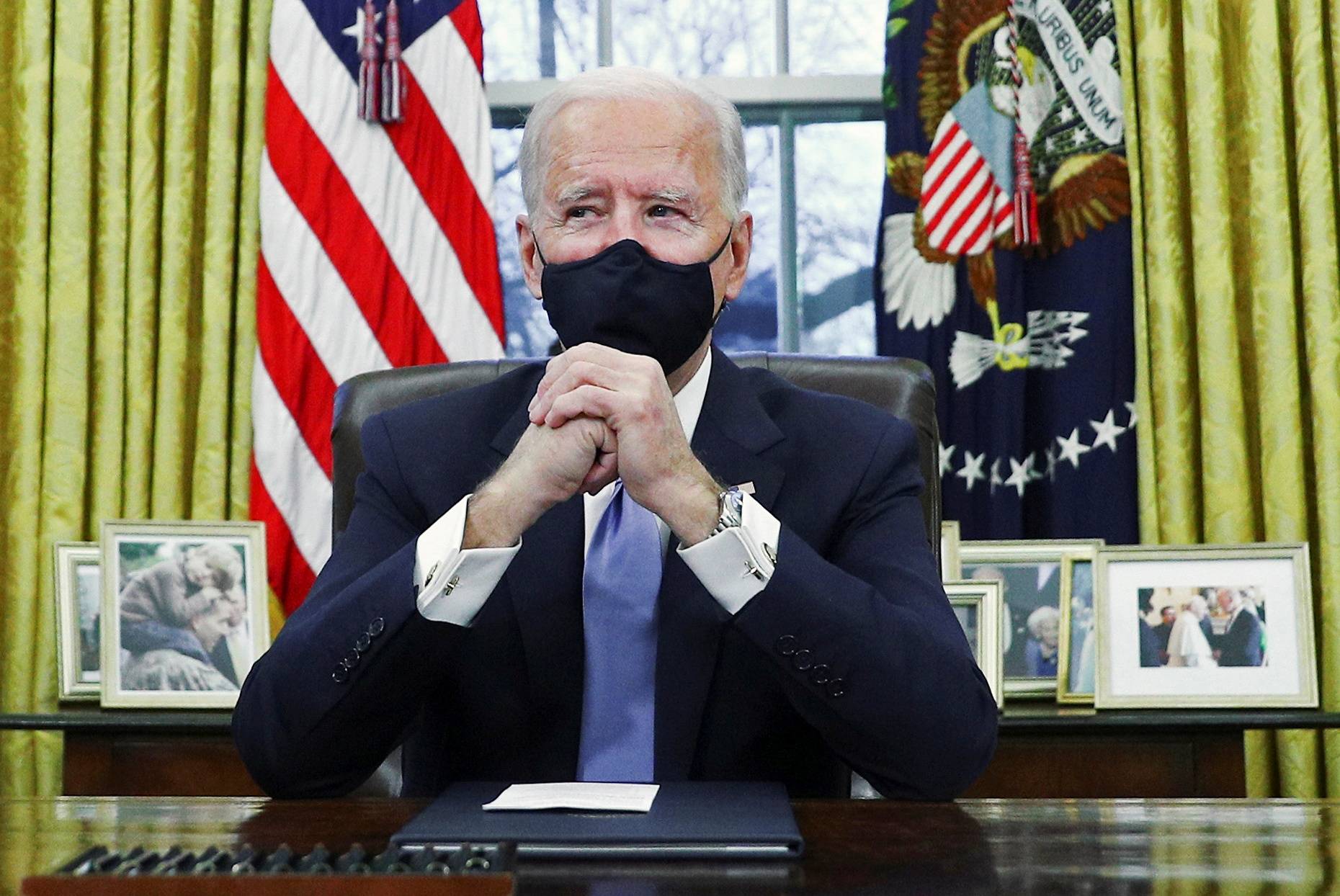 U.S. President Joe Biden signs executive orders in the Oval Office of the White House in Washington, after his inauguration as the 46th president of the United States on Wednesday. | REUTERS