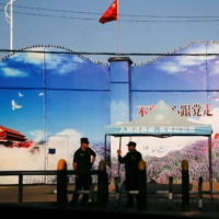 Security guards stand at the gates of what is officially known as a vocational skills education center in Huocheng County, in China\'s Xinjiang Uighur Autonomous Region, in 2018. | REUTERS 