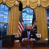 U.S. President Joe Biden prepares to sign a series of orders in the Oval Office of the White House on Wednesday.  | AFP-JIJI