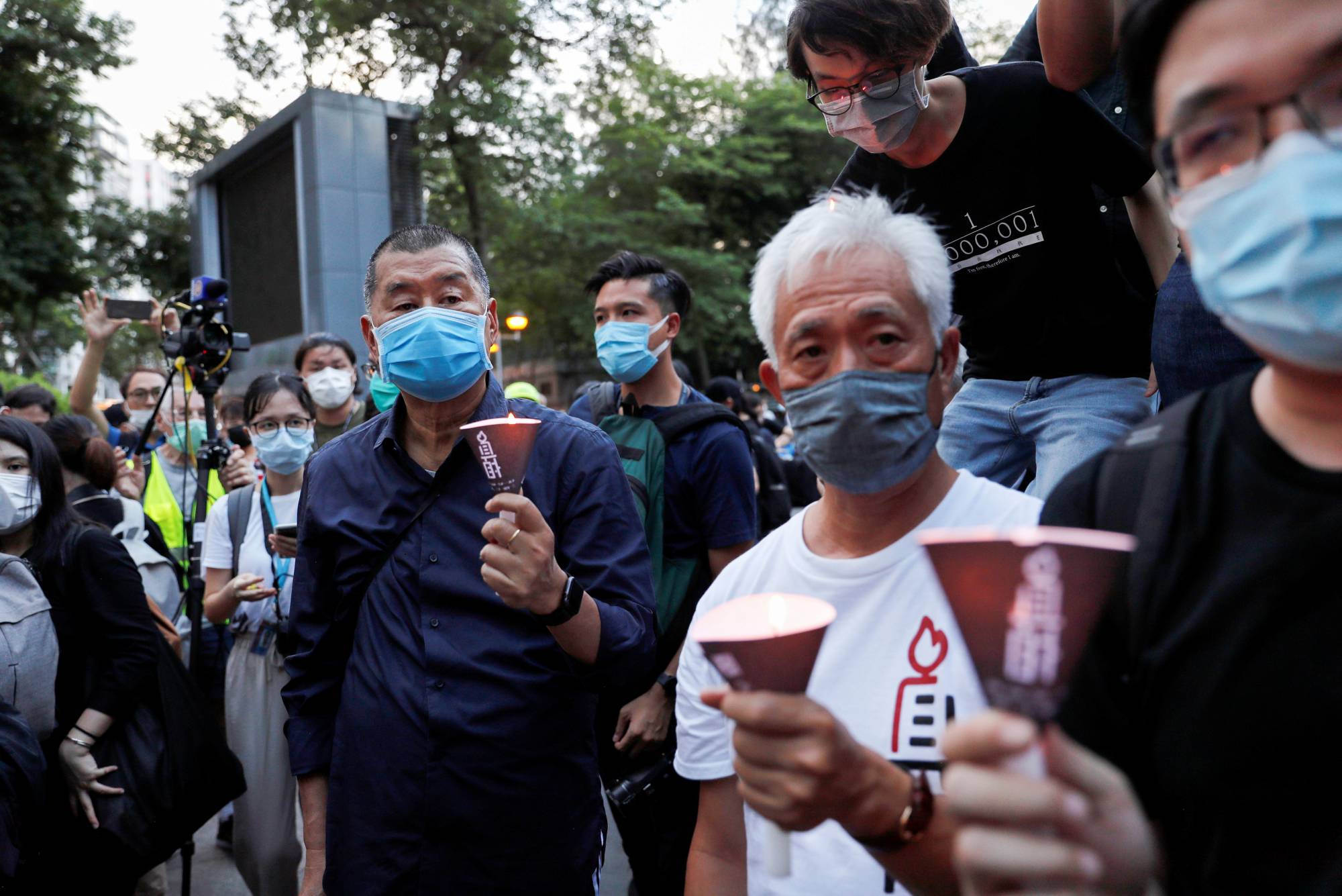 A candlelight vigil that included media mogul Jimmy Lai Chee-ying (left), founder of Apple Daily, is held in Hong Kong on June 4 to mark the 31st anniversary of the crackdown on pro-democracy protests at Beijing's Tiananmen Square in 1989.  | REUTERS
