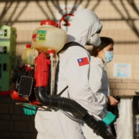 Soldiers prepare to spray disinfectant outside the Taoyuan General Hospital, where a cluster of coronavirus infections was detected in Taoyuan, Taiwan, on Tuesday.  | REUTERS