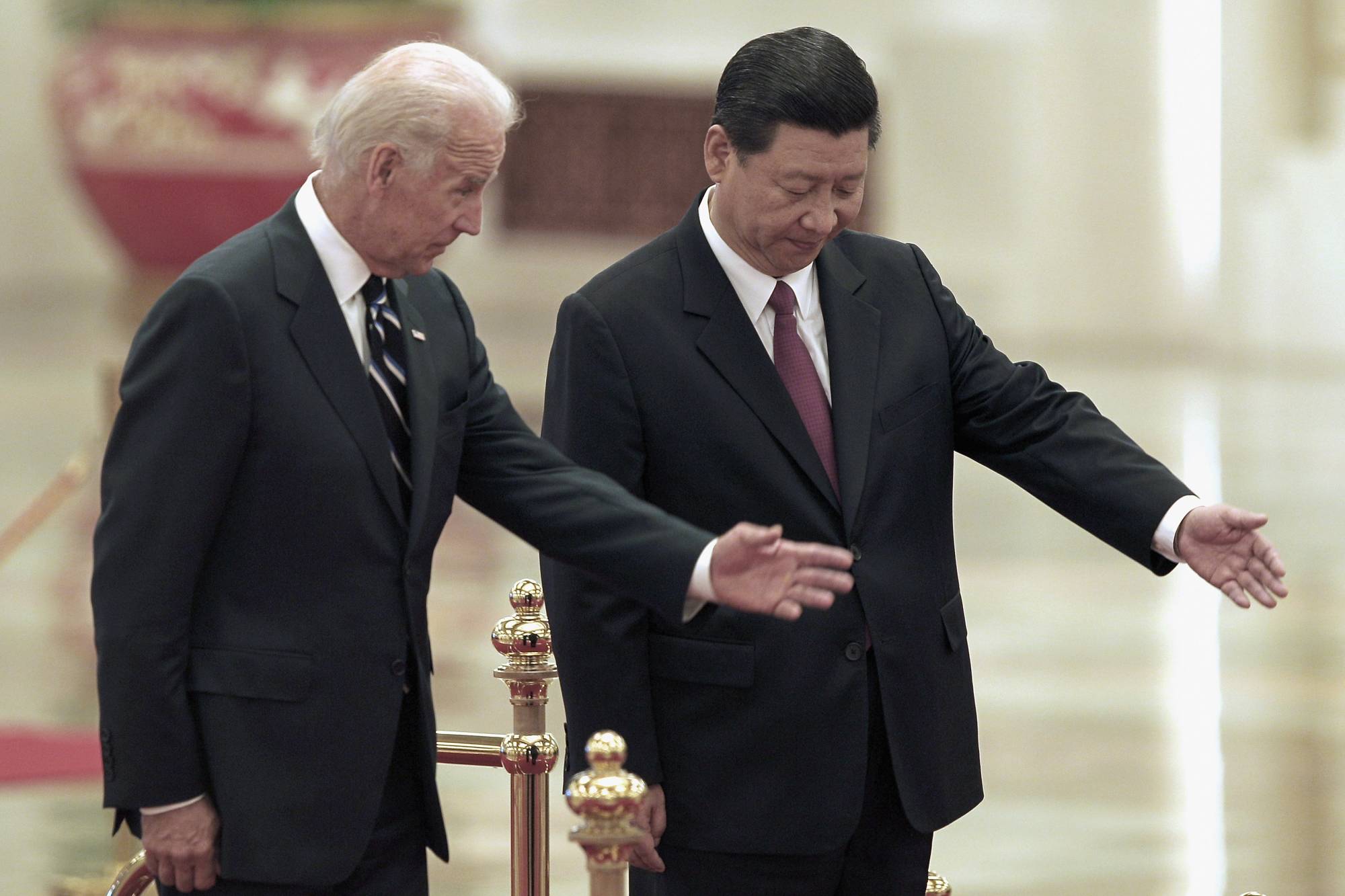 China's then-vice president, Xi Jinping, invites Joe Biden, then the U.S. vice president, to view an honor guard during a welcoming ceremony inside Beijing's Great Hall of the People in August 2011. | POOL / VIA REUTERS