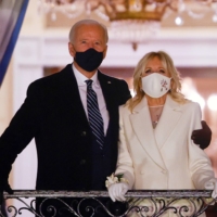 U.S. President Joe Biden and first lady Jill Biden watch fireworks from the White House after his inauguration as president of the United States on Wednesday.  | REUTERS