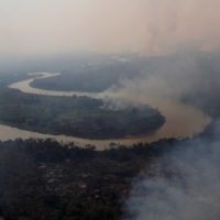 Smoke rises into the air around the Cuiaba river in the Pantanal, the world\'s largest wetland, in Pocone, Brazil, in August. | REUTERS