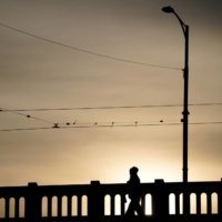 A woman walks across a usually busy bridge after lockdown restrictions were implemented in response to an outbreak of the coronavirus in Melbourne in July 2020. | REUTERS