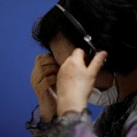 A volunteer responds to an incoming call at the Tokyo Befrienders call center, a suicide hotline center, on May 26, 2020. | REUTERS