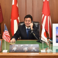 Defense Minister Nobuo Kishi speaks with new U.S. Defense Secretary Lloyd Austin over the phone at the Defense Ministry in Tokyo on Sunday. | DEFENSE MINISTRY