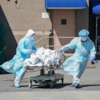 Bodies are moved to a refrigeration truck serving as a temporary morgue in New York in April last year.  | AFP-JIJI