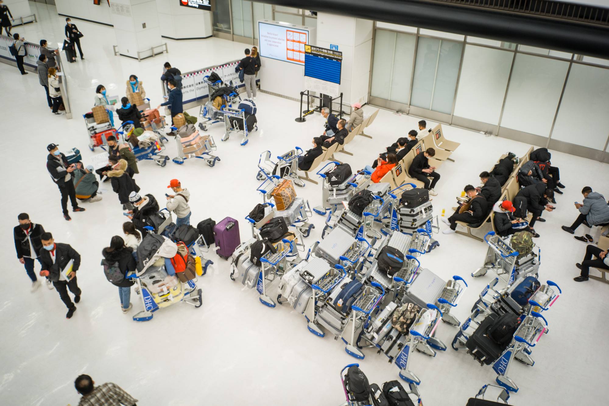 People assemble in front of the arrivals gate at Narita Airport in Narita, Chiba Prefecture, on Jan. 19. | BLOOMBERG