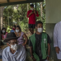 Brazilian indigenous people wait in Sao Paulo last Wednesday to receive the COVID-19 vaccine from the Chinese company Sinovac. Brazilian officials have complained that Chinese companies have been slow to ship the doses and ingredients.  | VICTOR MORIYAMA / THE NEW YORK TIMES