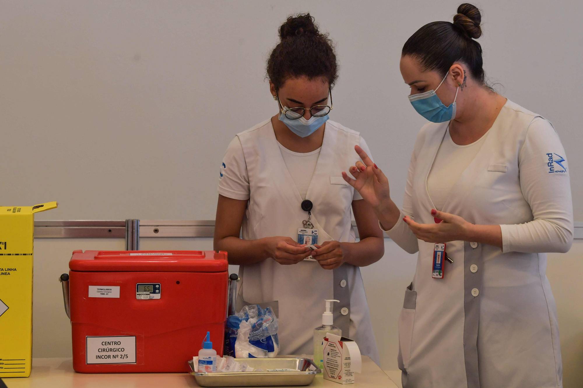 Health workers talk as they vaccinate colleagues with the Sinovac's vaccine at the Clinicas Hospital in Sao Paulo on Jan. 18. | AFP-Jiji