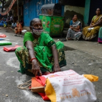 Residents wait in front of a government fair price ration shop to collect free gift hampers on the occasion of the Pongal harvest festival in Chennai on Jan. 4.  | AFP-JIJI