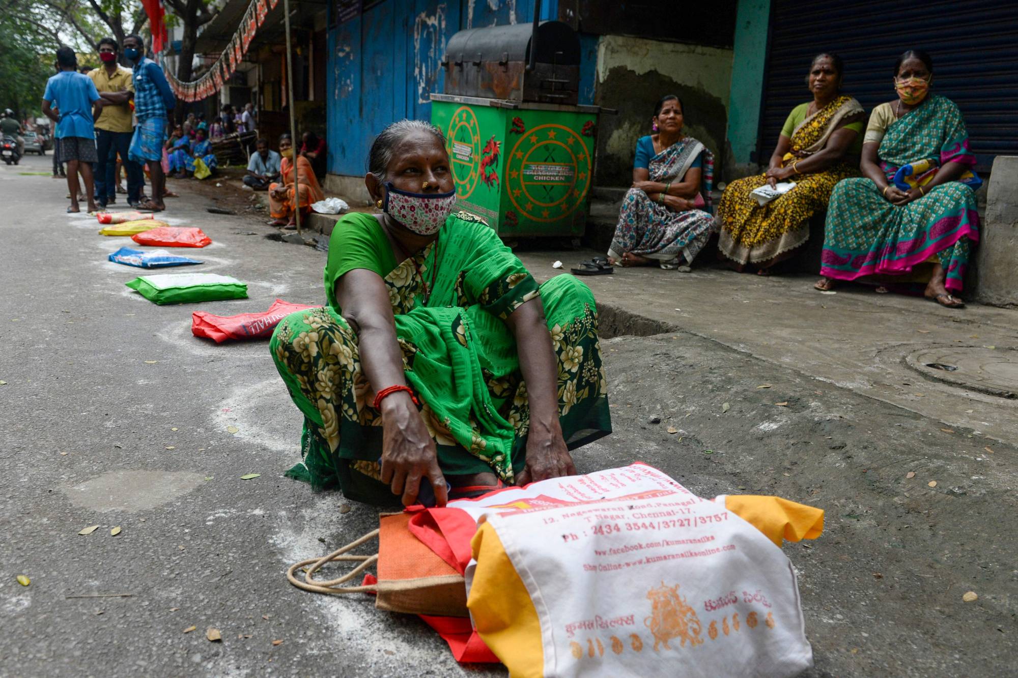 Residents wait in front of a government fair price ration shop to collect free gift hampers on the occasion of the Pongal harvest festival in Chennai on Jan. 4. | AFP-JIJI