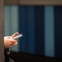 An office worker uses a smartphone on a station platform during morning rush hour in Frankfurt, Germany, in 2019. European lawmakers voted last week for the creation of new legal rights for employees to switch off from work-related tasks and electronic communication outside of office hours without facing consequences. | BLOOMBERG