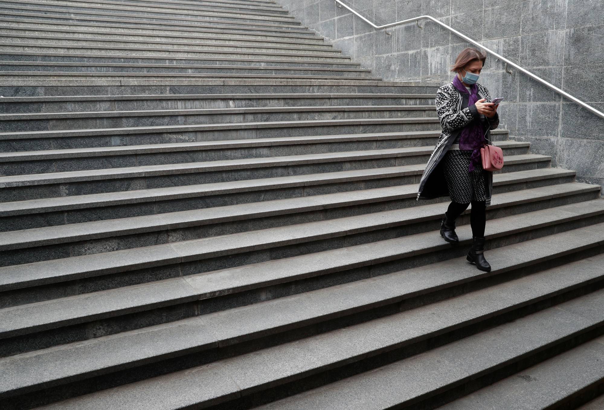A woman uses her smartphone while walking into an underpass in Kyiv, Ukraine, in October last year. European lawmakers voted last week for the creation of new legal rights for employees to switch off from work-related tasks and electronic communication outside of office hours without facing consequences. | REUTERS