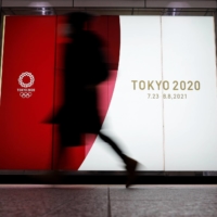 A person walks past an advertisement for the 2020 Tokyo Olympics on Jan. 22.  | REUTERS