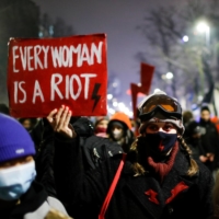 Demonstrators hold placards during a protest against a verdict restricting abortion rights, in Warsaw on Thursday. | REUTERS