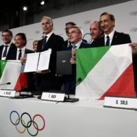 Italian National Olympic Committee (CONI) President Giovanni Malago, Mayor of Milan Giuseppe Sala, Mayor of Cortina Gianpietro Ghedina and IOC President Thomas Bach pose after Milano and Cortina won the bid to host the 2026 Winter Olympic Games, at the SwissTech Convention Centre in Lausanne, Switzerland, in June 2019. | POOL / VIA REUTERS 