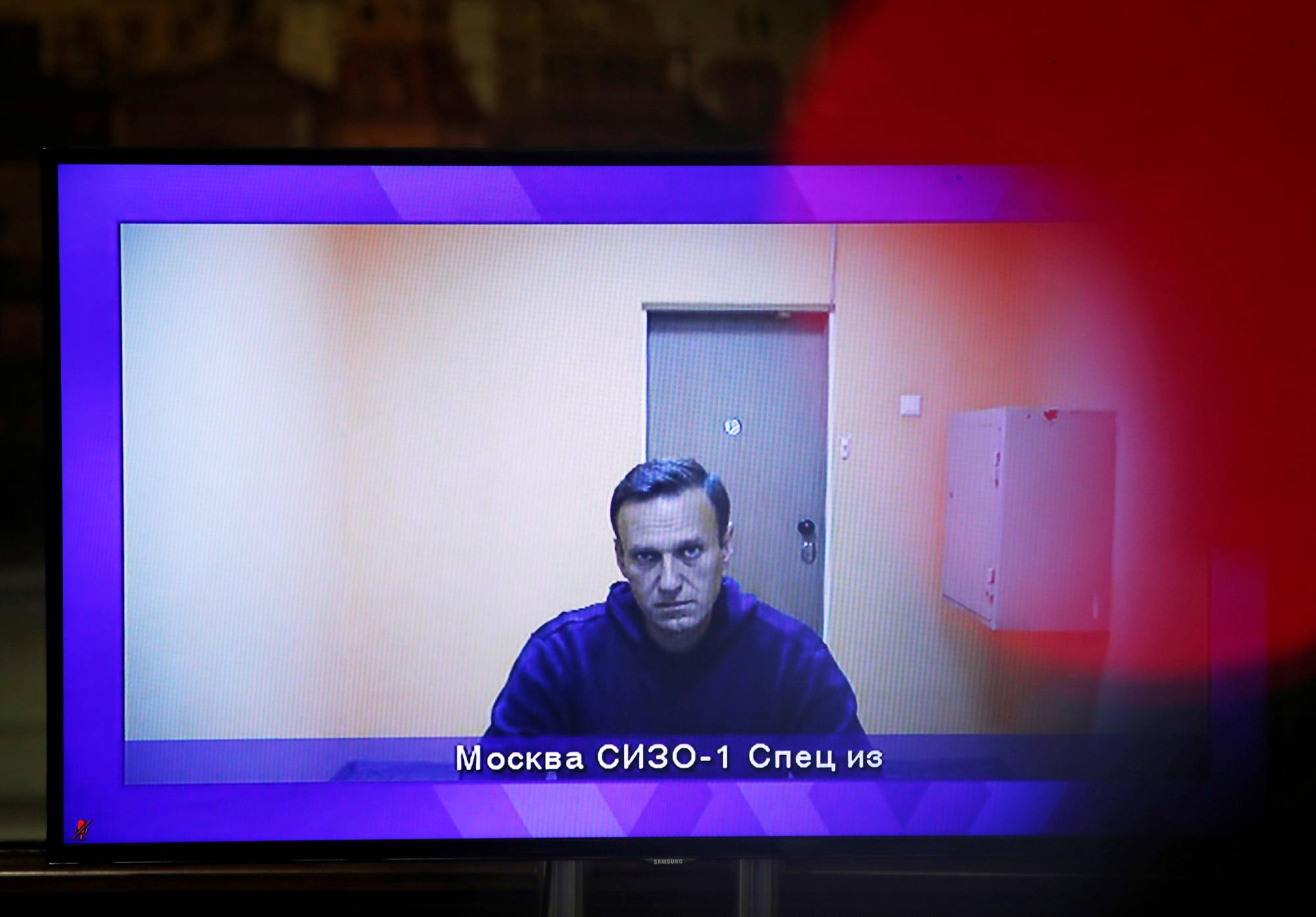 Russian opposition leader Alexei Navalny is seen on a screen via a video link during a court hearing to consider an appeal on his arrest outside Moscow on Thursday. | REUTERS