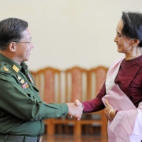 Myanmar military chief Gen. Min Aung Hlaing and National League for Democracy party leader Aung San Suu Kyi shake hands after their meeting at the commander in-chief\'s office in Naypyidaw, Myanmar, in December 2015. | AFP-JIJI