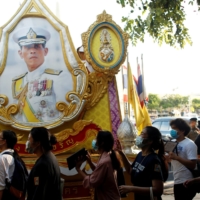 Demonstrators walk past a portrait of Thai King Maha Vajiralongkorn during a protest demanding the resignation of Prime Minister Prayut Chan-ocha in Bangkok in July last year.  | REUTERS