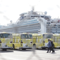 Buses wait for disembarking passengers to leave the coronavirus-hit Diamond Princess cruise ship in Yokohama.  | RYUSEI TAKAHASHI
