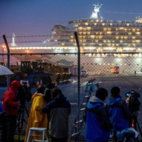 Media crews gather behind a fence near the Diamond Princess cruise ship at Daikoku Pier Cruise Terminal in Yokohama on Feb. 16, 2020. | REUTERS