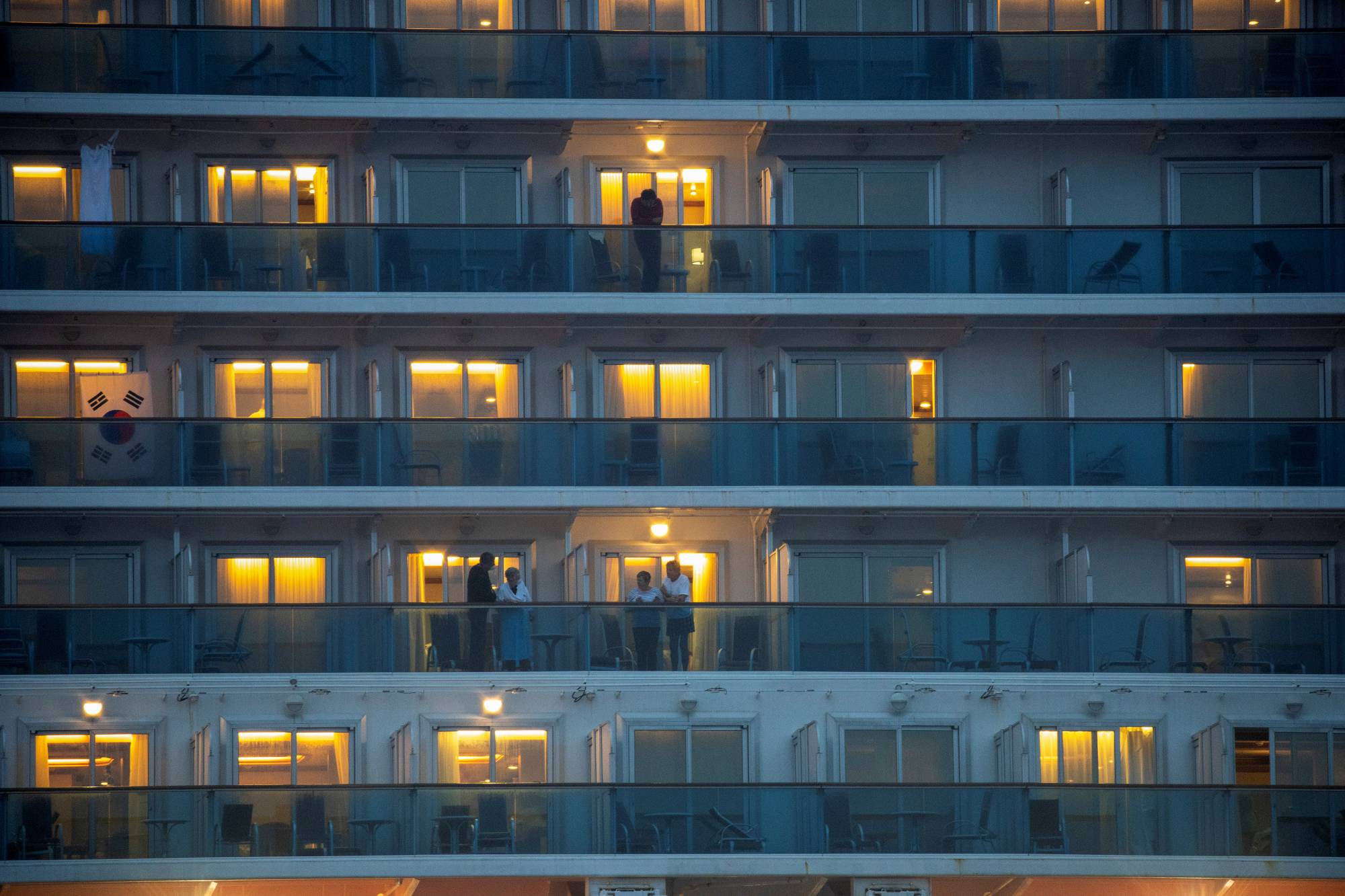 Passengers chat with neighbors on adjoining balconies on the Diamond Princess cruise ship in Yokohama on Feb. 16, 2020. | REUTERS