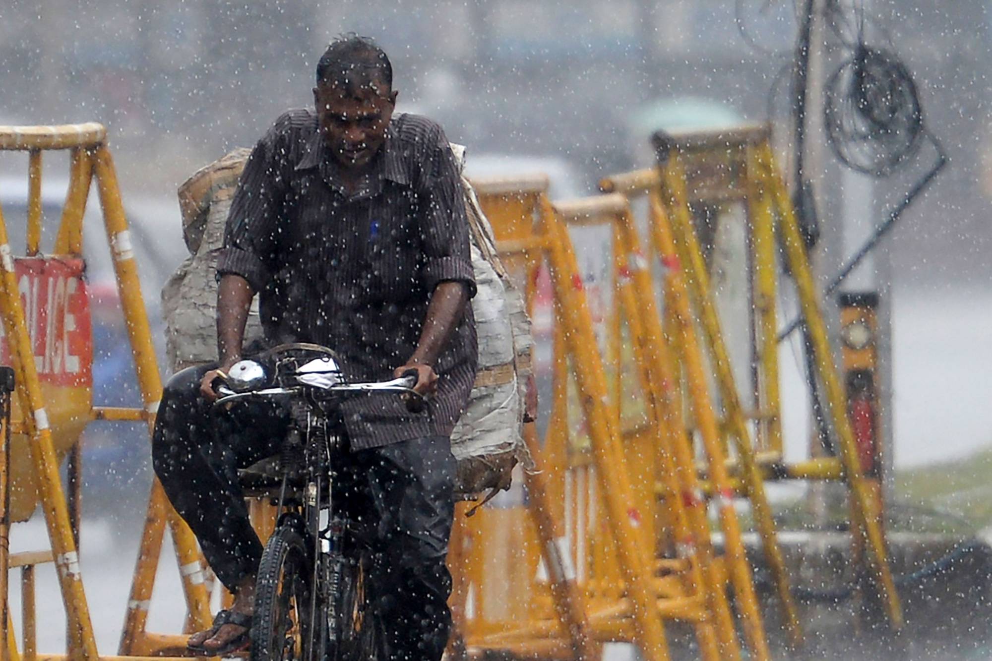 A commuter rides past during heavy rains in Chennai on Jan. 6.  | AFP-Jiji