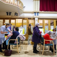 People receive COVID-19 vaccines in Chesterfield, England, on Wednesday. | REUTERS 