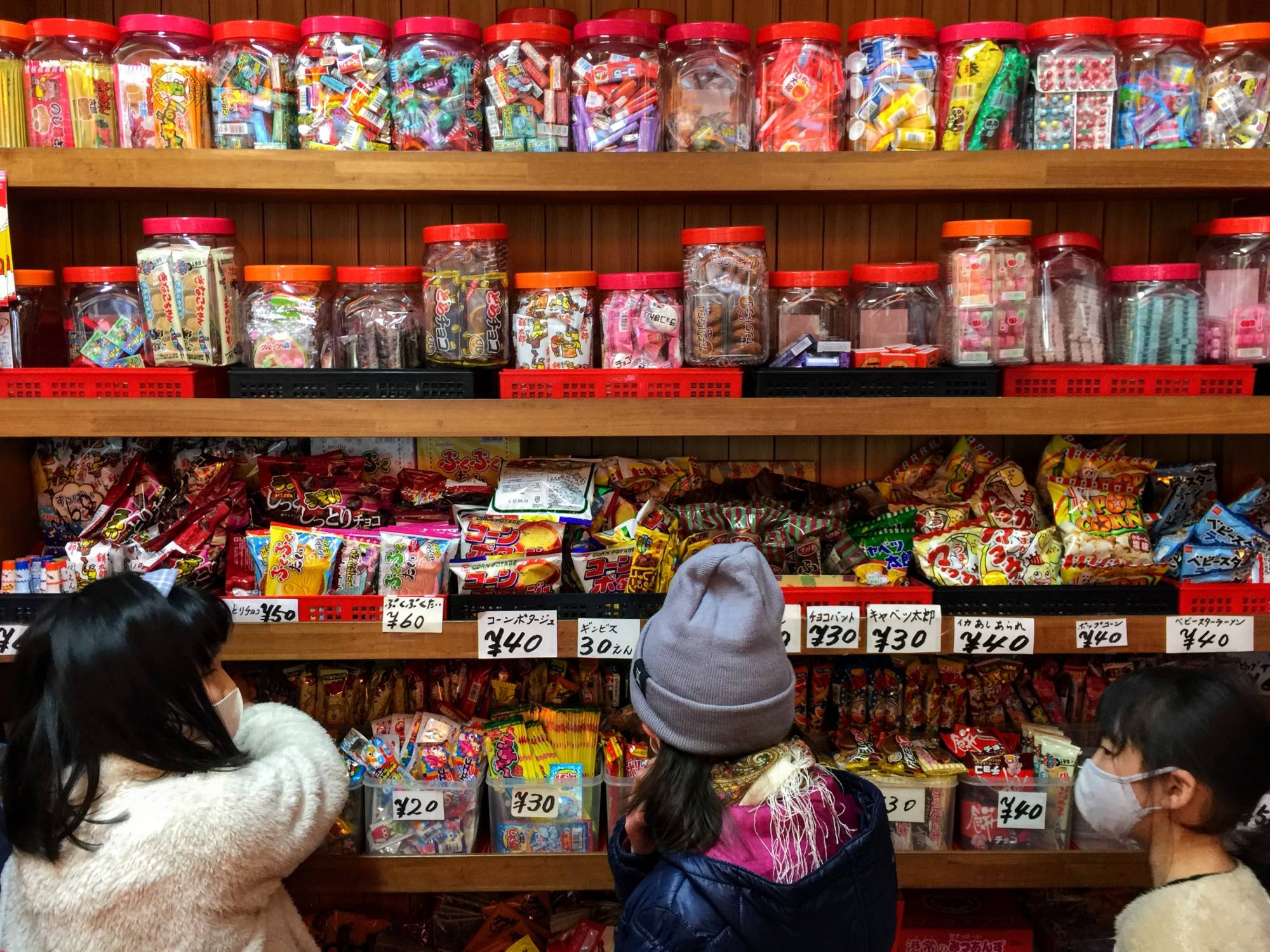 Pick n’ mix: Children browse the colorful, packed shelves of a traditional <em>dagashiya</em> (old-fashioned sweets shop). | REBECCA SAUNDERS