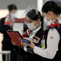 Employees of Japan Airlines at the departure zone of Narita Airport in November. | REUTERS