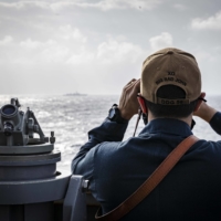 U.S. Cmdr. Joseph Gunta, the executive officer of the USS John S. McCain destroyer, observes a ship from the vessel\'s bridge near the Paracel Islands in the South China Sea on Friday. | U.S. NAVY