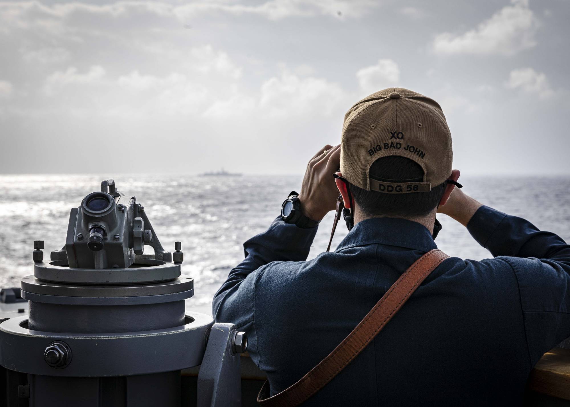 U.S. Cmdr. Joseph Gunta, the executive officer of the USS John S. McCain destroyer, observes a ship from the vessel's bridge near the Paracel Islands in the South China Sea on Friday. | U.S. NAVY