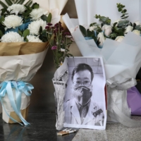 A makeshift memorial for Li Wenliang, a doctor who issued an early warning about the coronavirus outbreak before it was officially recognized, is seen after Li died of the virus, at an entrance to the Central Hospital of Wuhan, China on Feb. 7, 2020.  | REUTERS