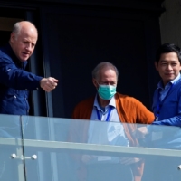 Peter Daszak (left) and Hung Nguyen-Viet (right), members of the World Health Organization team tasked with investigating the origins of COVID-19, stand on the balcony of their hotel in Wuhan, China, on Saturday.  | REUTERS 