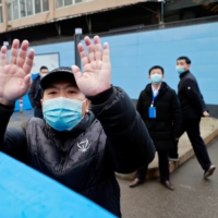 Security personnel secure the gate to Huanan seafood market on Jan. 31 during a visit by a World Health Organization team probing the origins of COVID-19.  | REUTERS 