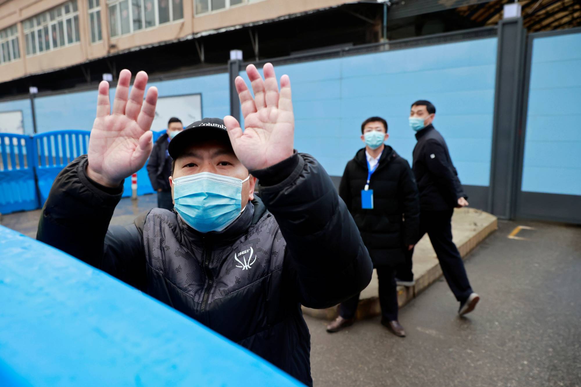 Security personnel secure the gate to Huanan seafood market on Jan. 31 during a visit by a World Health Organization team probing the origins of COVID-19. | Reuters 