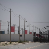 Chinese flags line a road leading to a facility believed to be a re-education camp where mostly Muslim ethnic Uighur are detained, on the outskirts of Hotan in China\'s northwestern Xinjiang region in May 2019.  | AFP-JIJI