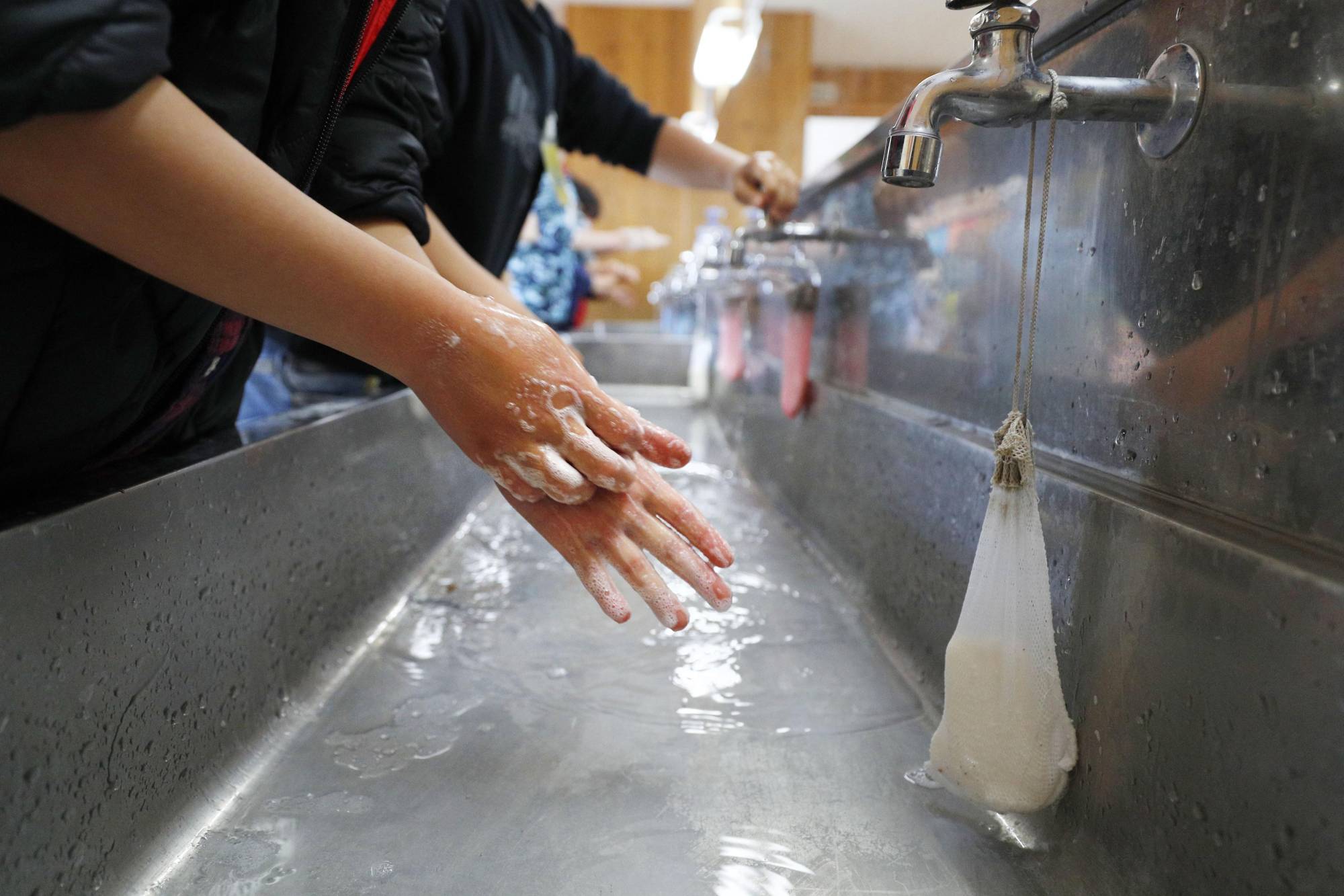 Students wash their hands at their elementary school in Shizuoka on March 16, 2020, amid the early spread of the novel coronavirus in Japan. | KYODO