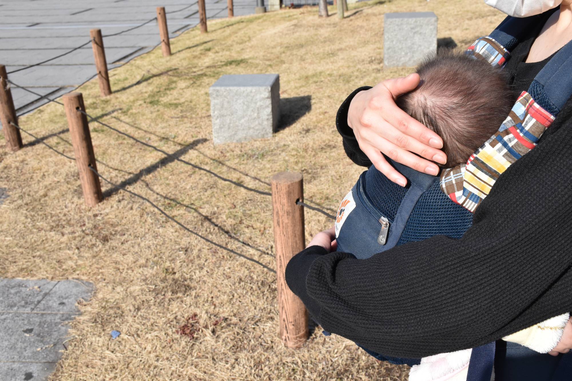 A 28-year-old woman carries her youngest daughter. She has called for a raise to the amount paid to new mothers under Japan’s lump-sum childbirth allowance program. | NISHINIPPON SHIMBUN